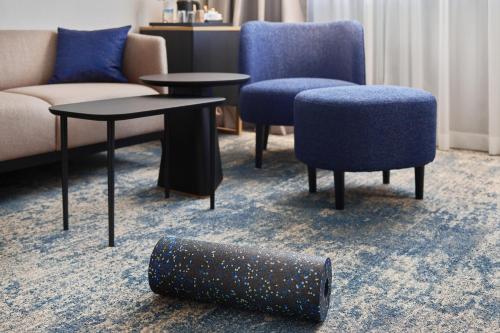 萨格勒布Maistra City Vibes Hotel International的客厅配有沙发、椅子和桌子