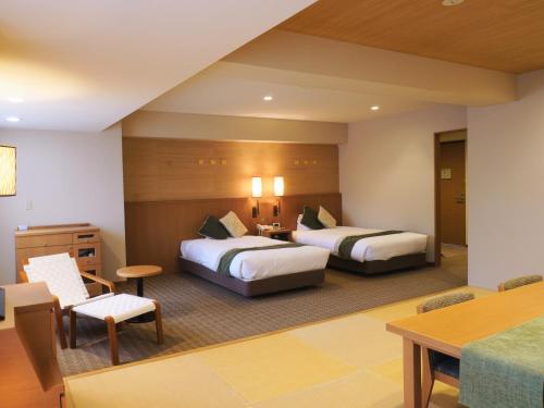 登别登别汤本温泉酒店的酒店客房设有两张床和一张桌子。