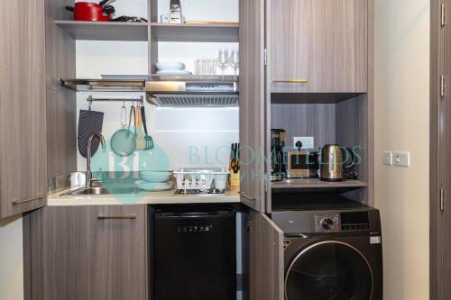 Al QurayyahElegant Studio In Leonardo的厨房配有洗碗机、洗衣机和烘干机。