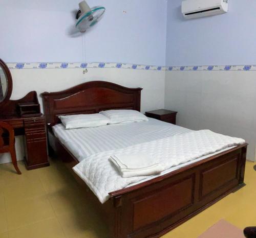 胡志明市Phúc Lộc Thọ Hotel的一间卧室配有一张床、梳妆台和风扇