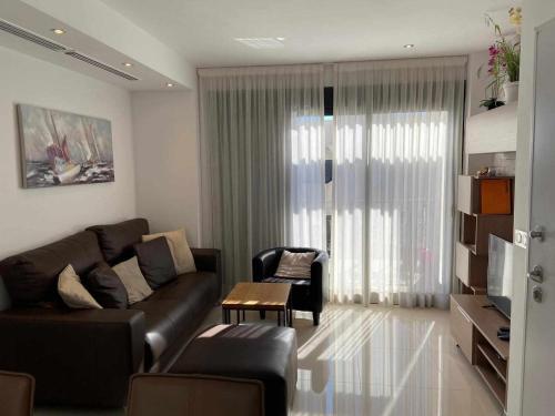 弗拉门卡海滩La zenia Bulevard apartments的客厅配有真皮沙发和桌子
