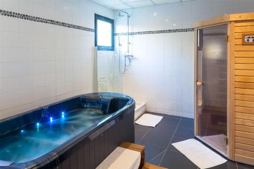 维姆勒圣简酒店的一间带大浴缸和淋浴的浴室