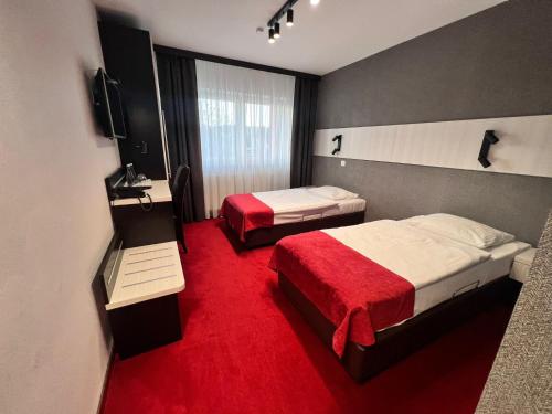 普鲁德尼克Hotel Olimp的酒店客房,设有两张床,铺有红地毯。