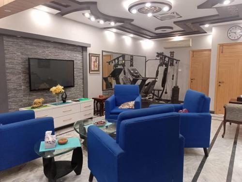 卡拉奇White Lotus Karachi的客厅配有蓝色椅子和电视