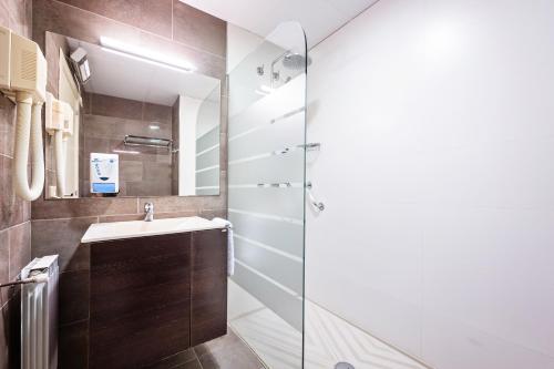 奥洛特奥洛特珍珠酒店的一间带水槽和玻璃淋浴的浴室