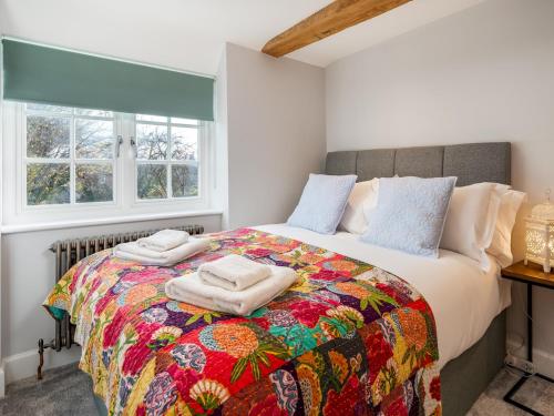 阿默舍姆Pass the Keys Converted Hop House Apt - Old Amersham - Chilterns的一间卧室配有一张大床和五颜六色的被子