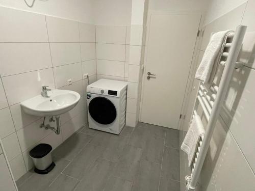 路德维希堡Timeless: Große Moderne 4 Zimmer Wohnung的小型浴室设有洗衣机和水槽。