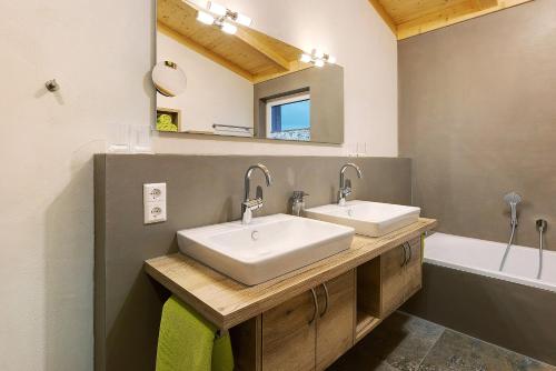 多瑙艾辛根Ferienwohnungen Bosserthof的浴室设有2个水槽、镜子和浴缸。