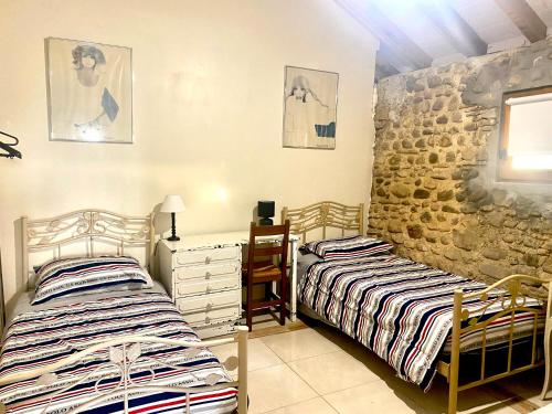 莫南Domaine de Berducq的一间卧室设有两张床和石墙