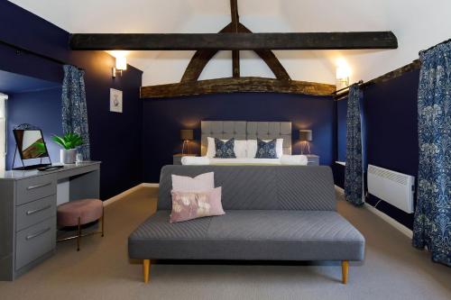 奇切斯特Canon Gate的一间卧室设有蓝色的墙壁和一张沙发