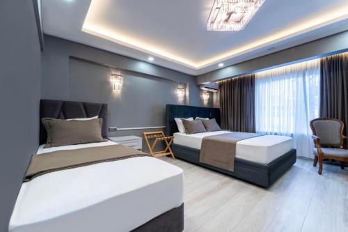 伊斯坦布尔Classio Hotel Kadıköy的一间卧室配有两张床、一张沙发和一把椅子