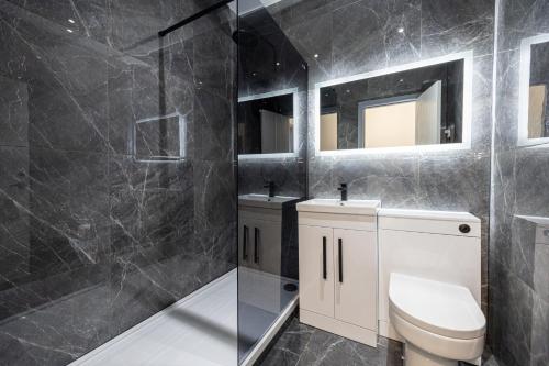 博尔顿Stunning Bolton Abode - Cinema Experience - Parking的浴室配有卫生间、两个盥洗盆和淋浴。