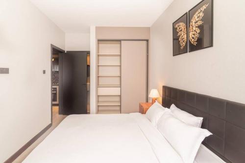 内罗毕Cozy 2 Bedroom Apt at Escada (506)的卧室配有白色大床和白色枕头