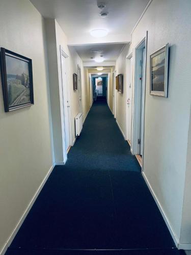 马尔默Cilla och Smillas AB的大楼里长长的走廊,有蓝色的地毯