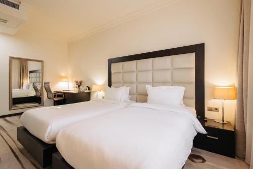 埃里温埃里温巴黎酒店的一张大白色的床,位于酒店客房内