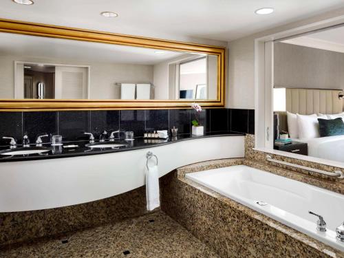 里士满温哥华机场航站楼费尔蒙酒店的一间带浴缸和大镜子的浴室