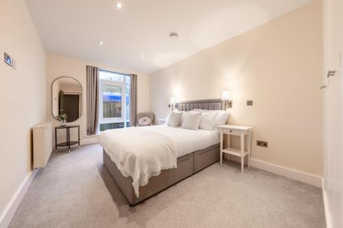 特威克纳姆Candler Mews - Twickenham的白色的卧室设有一张大床和一个窗户