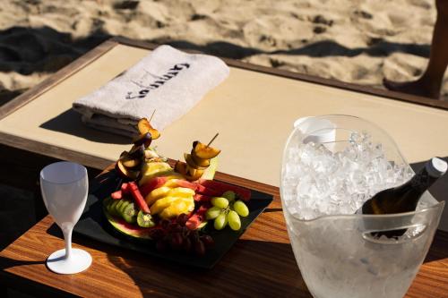 尼欧波洛伊奥运之星海滩公寓式酒店的一张桌子,上面放着一盘水果和一瓶葡萄酒