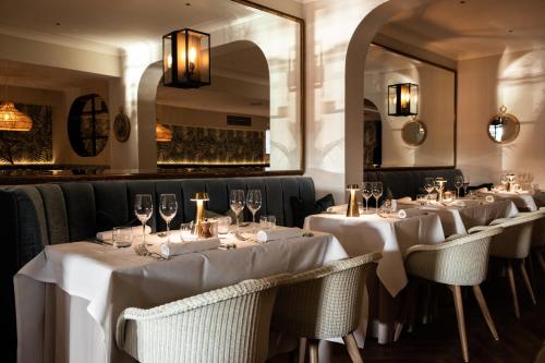 格雷The Moorings Hotel & Restaurant的餐厅的一排桌子,有白色桌布
