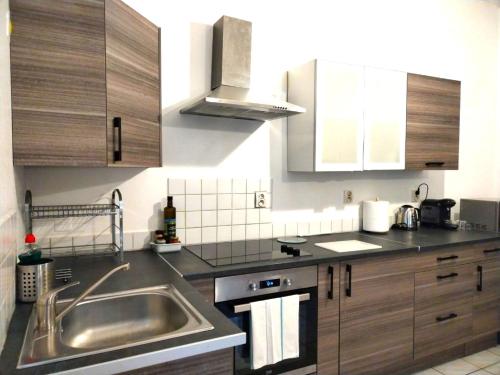 波城A Deux Pas des Halles - Hypercentre - Idéal Couple的厨房配有不锈钢盥洗盆和木柜