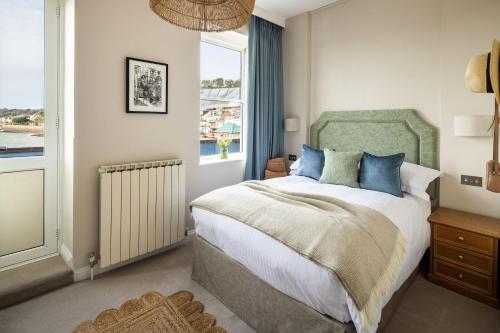 格雷The Moorings Hotel & Restaurant的一间卧室配有一张带蓝色枕头的床和一扇窗户。