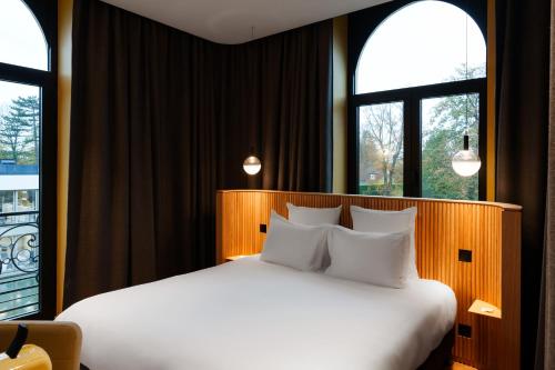 瓦斯凯勒La Maison des Bienheureux的卧室配有白色床和2扇窗户