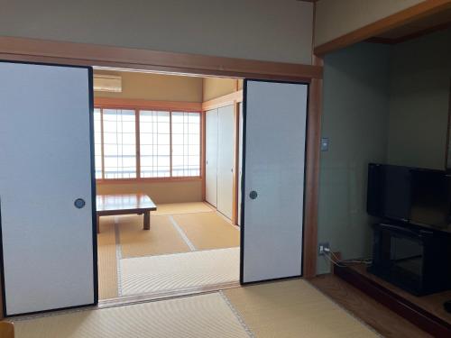 田边市龙津温泉丸井旅馆 的一间设有门的房间,可通往客厅