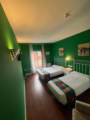 比利亚夫利诺Orquídea Real的绿色客房 - 带两张床和绿色墙壁