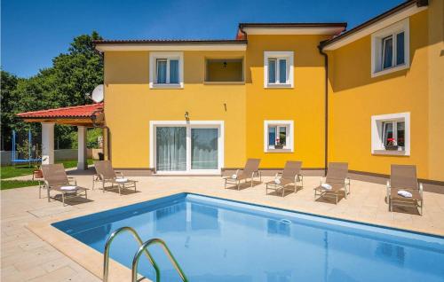 莫什尼卡德拉加Villa Terra的黄色的房子,设有游泳池和椅子