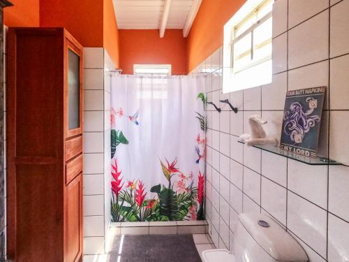克拉伦代克博内尔岛海珍宝酒店的浴室设有鲜花和淋浴帘。