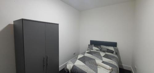 考文垂Coventry Rise Home的一间卧室配有一张床和一个黑色橱柜