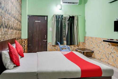 PhundardihHotel Welcome Sri Vip Road Raipur的一间卧室配有红色枕头的床