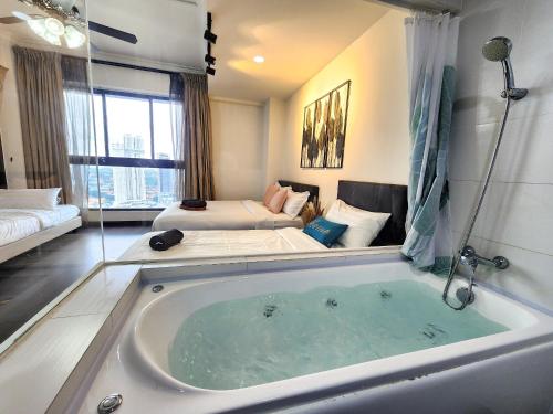 新山Loft Suite City View JB CIQ 7Pax的配有床的房间的大浴缸