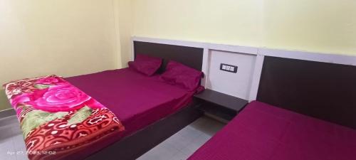 巴德里纳特Badrinath Jbk by Prithvi Yatra Hotel的一间卧室配有一张带紫色床单和粉色枕头的床。