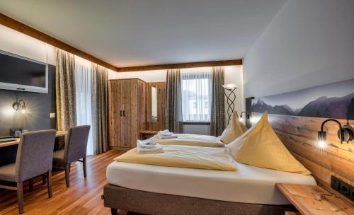 基姆湖畔普林König Ludwig Stub´n的酒店客房设有一张大床和一张书桌。