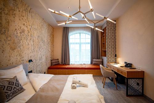 贝凯什圣安德拉什Bordűr Wellness Hotel Superior és Szőnyegmúzeum的一间卧室配有一张床、一张书桌和一个窗户。