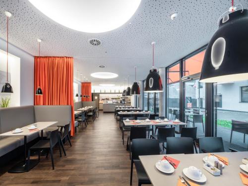 海德堡博丁哈斯7天酒店的用餐室设有桌椅和窗户。