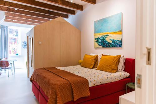 多德雷赫特B&B À la Lon的一间卧室配有黄色和橙色枕头的床