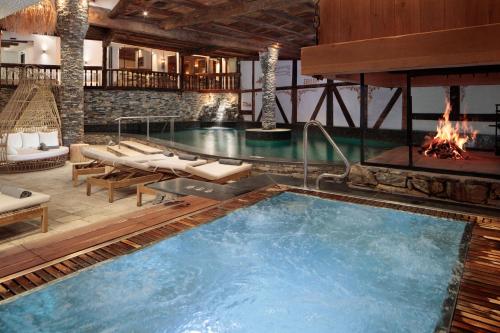 克莱恩 蒙塔纳Aïda Hôtel & Spa - "Adults Only" Relais & Châteaux的带壁炉的大型游泳池