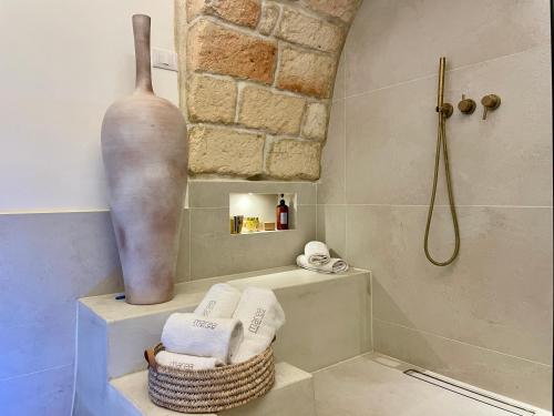 纳尔多I Granai - Marea Collection的带淋浴、花瓶和毛巾的浴室
