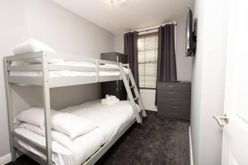 伯肯黑德Lavish 2Bed Apartment in the Heart of Birkenhead的一间卧室设有两张双层床和一扇窗户。
