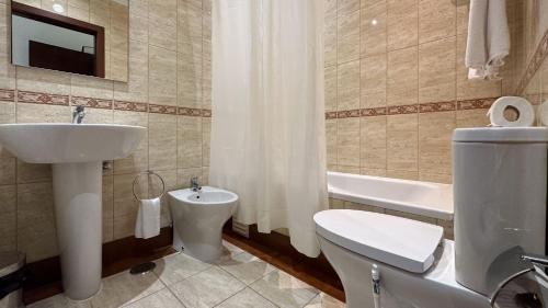 波尔蒂芒普拉亚大道酒店的浴室配有盥洗盆、卫生间和浴缸。