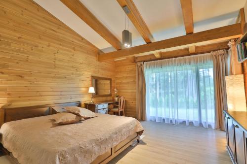 班斯科Luxury Chalets Pirin Golf & Country Club的一间卧室设有一张床和木墙