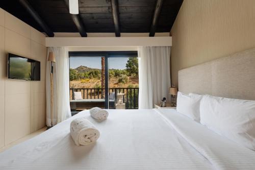 蒙达香缇索姆酒店的卧室配有带毛巾的大型白色床