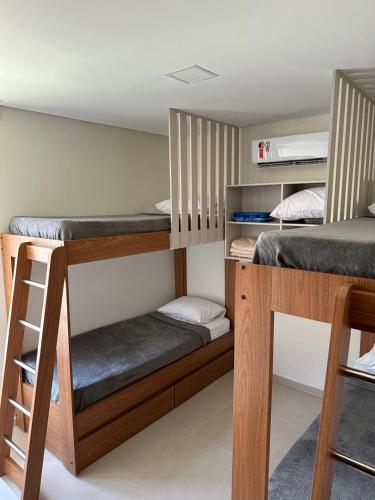 塔曼达雷Reserva dos Carneiros 301的客房设有两张双层床和梯子