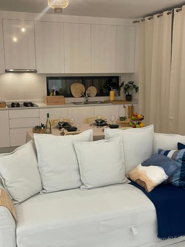 明德卢Ocean View Santa Filomena的厨房里配有带枕头的白色沙发