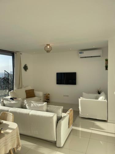 明德卢Ocean View Santa Filomena的客厅配有白色沙发和平面电视。