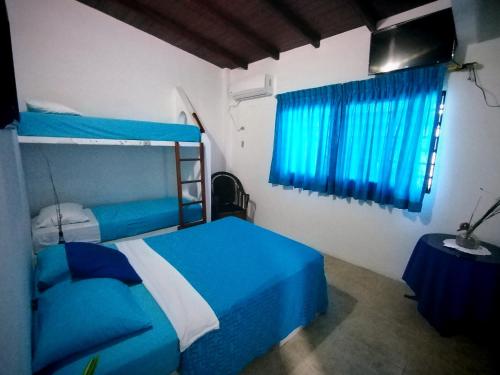 萨利纳斯Hotel Cocos的一间卧室配有蓝色的床和蓝色窗帘