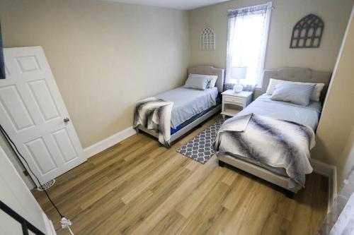 费城Cozy Modern 3 bedroom Home in west Philly的一间卧室设有两张床,铺有木地板