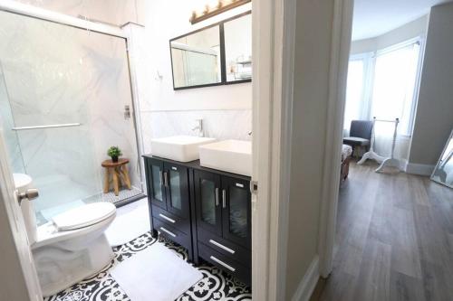 费城Cozy Modern 3 bedroom Home in west Philly的一间带水槽、卫生间和镜子的浴室
